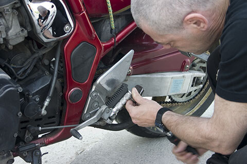 A guy checking out an issue on a motorcycle.